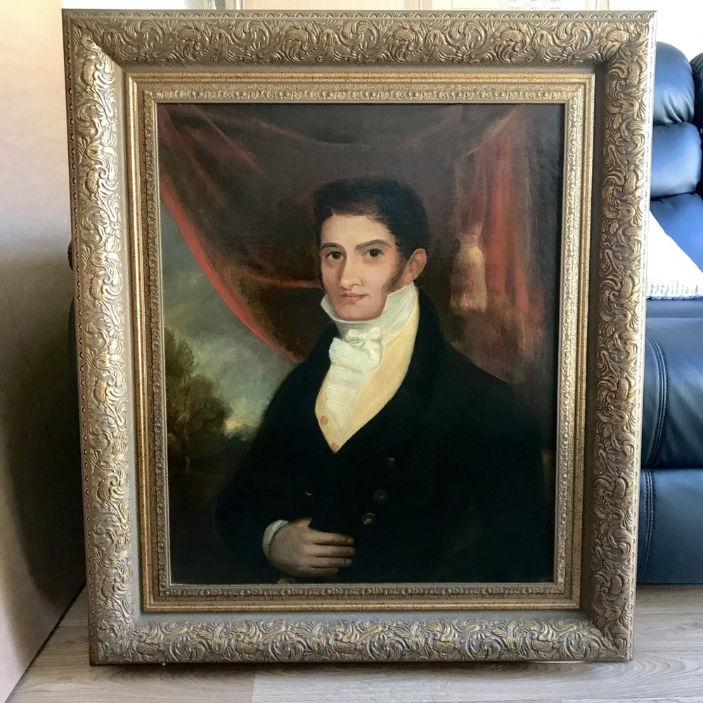 An antique oil painting depicting a Regency gentleman in a dark coat and white cravat, set within an ornate, carved gold frame. View XIII