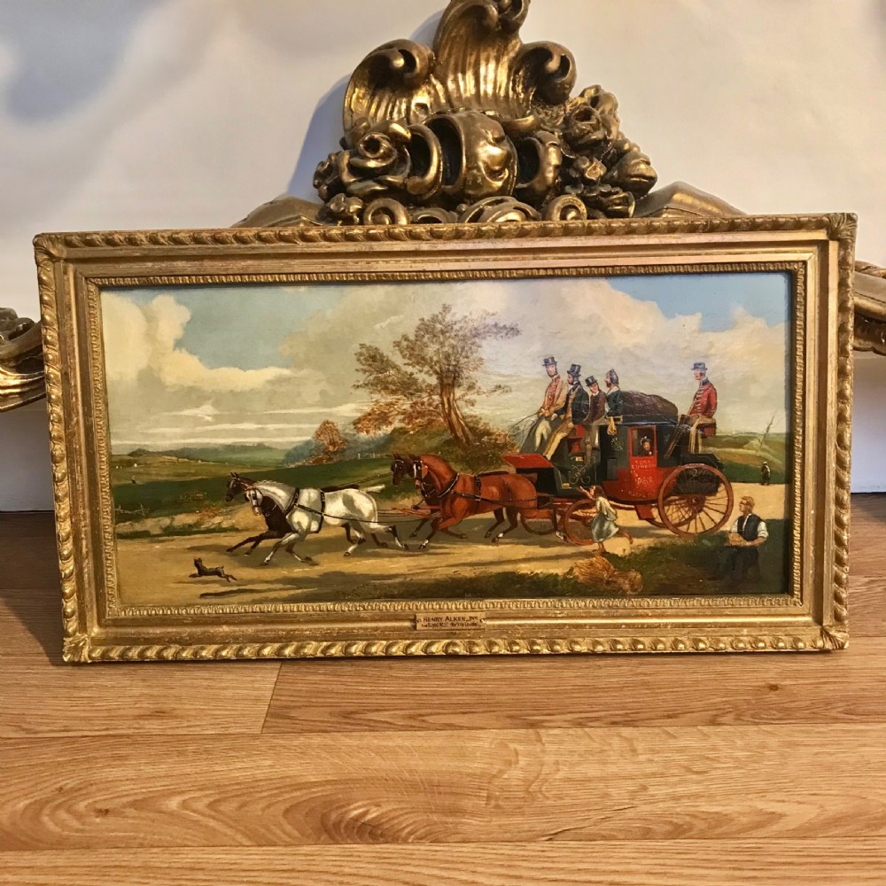 A horizontal oil painting depicting a red Royal Mail coach pulled by four horses along a dirt road in a gilded wooden frame.