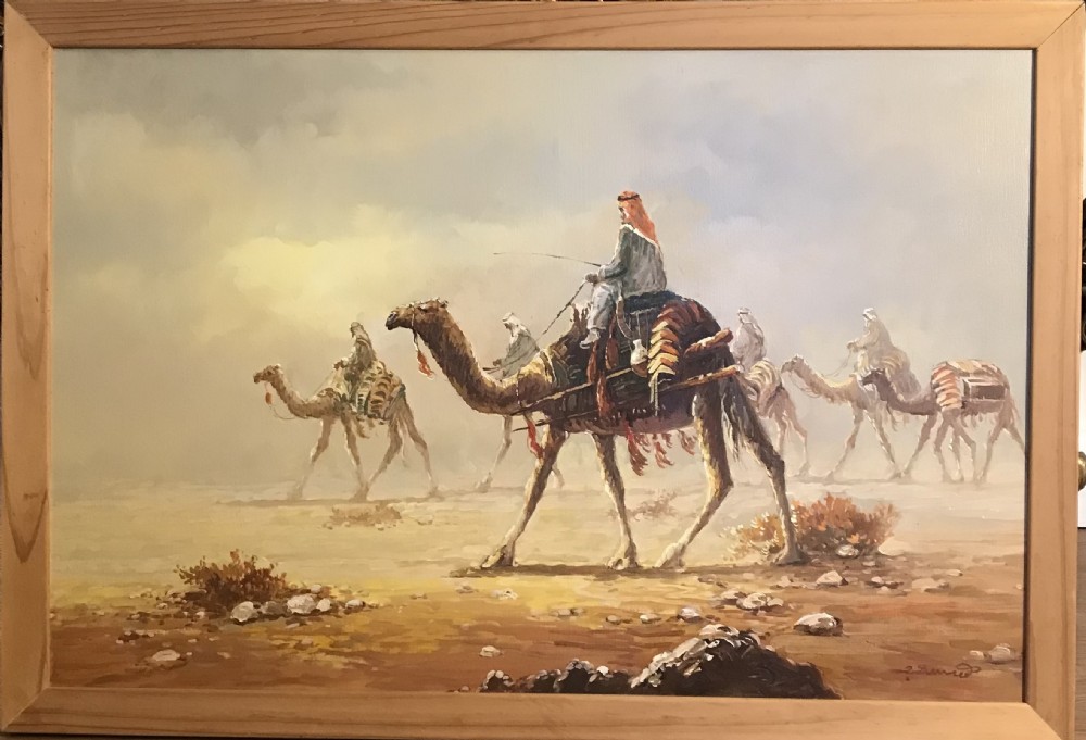 An oil painting on canvas depicting a Bedouin camel caravan traversing a desert landscape under a hazy sky, encased in a simple light wood frame. View XV