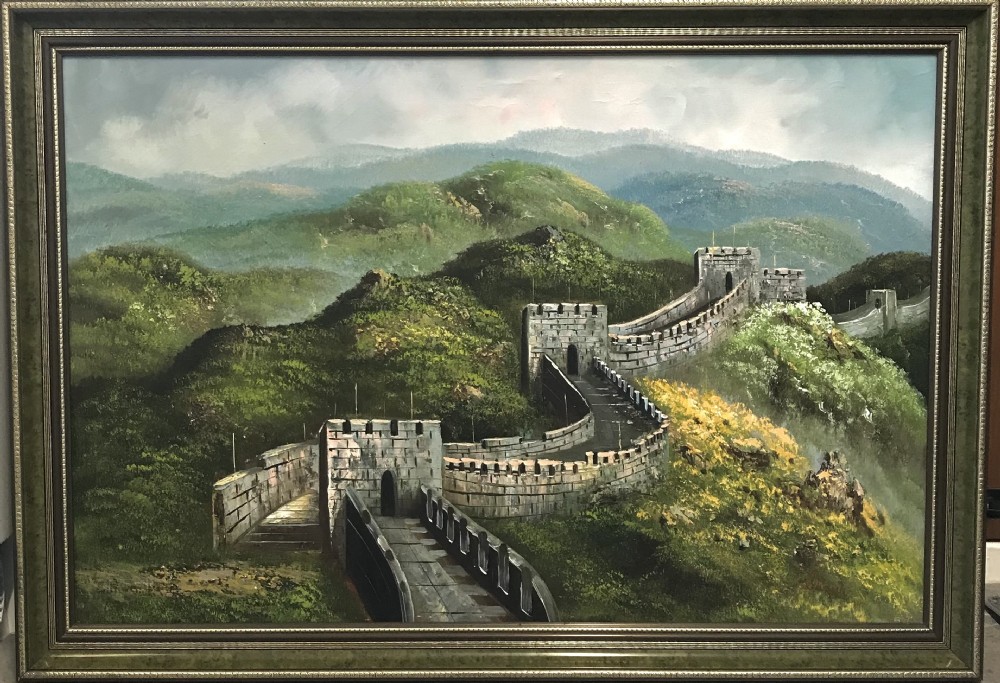 A large horizontal oil painting depicting the Great Wall of China winding through lush green mountains under a cloudy sky, encased in a metallic green and gold frame. View XVII