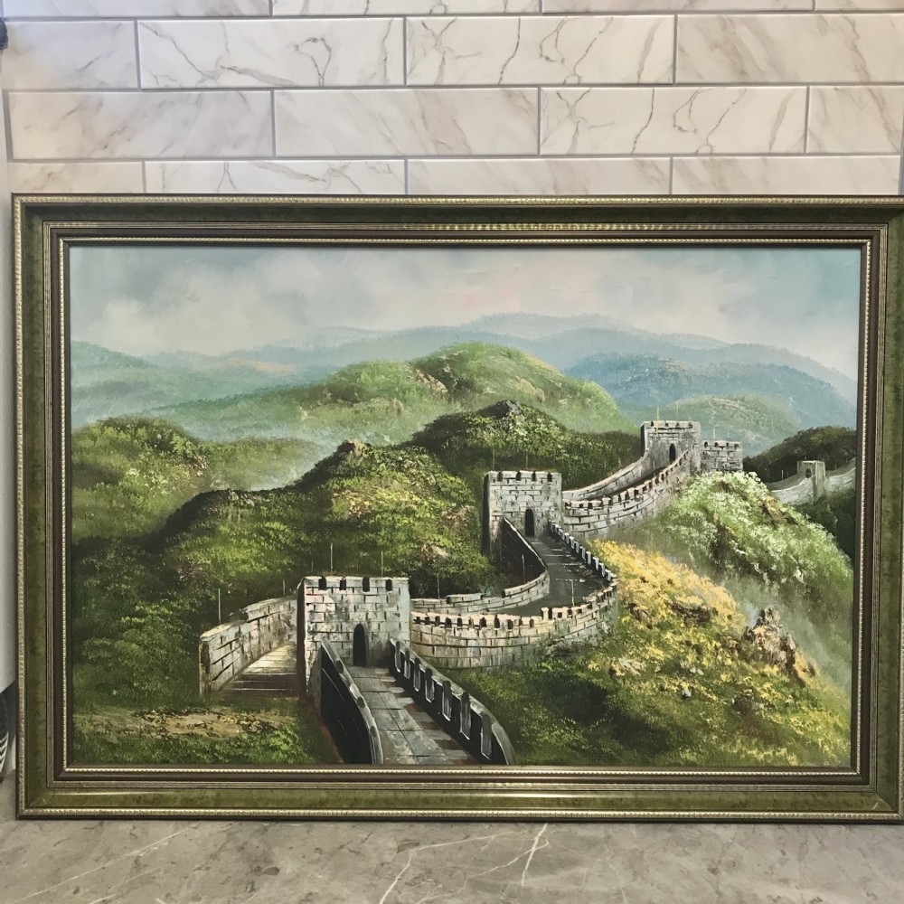 A large horizontal oil painting depicting the Great Wall of China winding through lush green mountains under a cloudy sky, encased in a metallic green and gold frame. View II