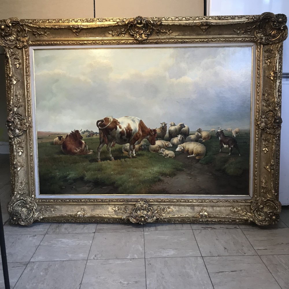 A Victorian pastoral oil painting depicting a reddish-brown and white cow standing alongside several resting sheep in a grassy pasture. View XXVI