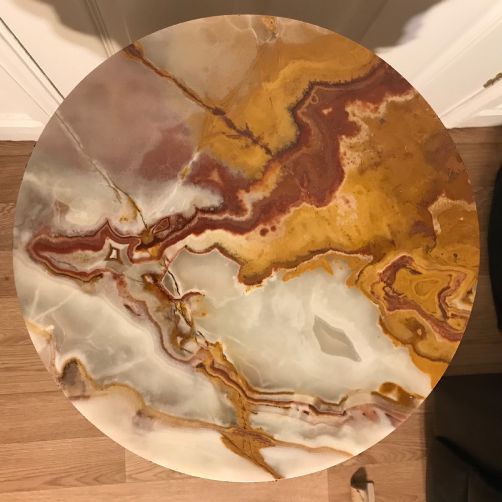 A 19th-century French round table featuring a variegated onyx top, a gilt frieze with decorative mouldings, and three carved column supports above a triangular base. View XXIX
