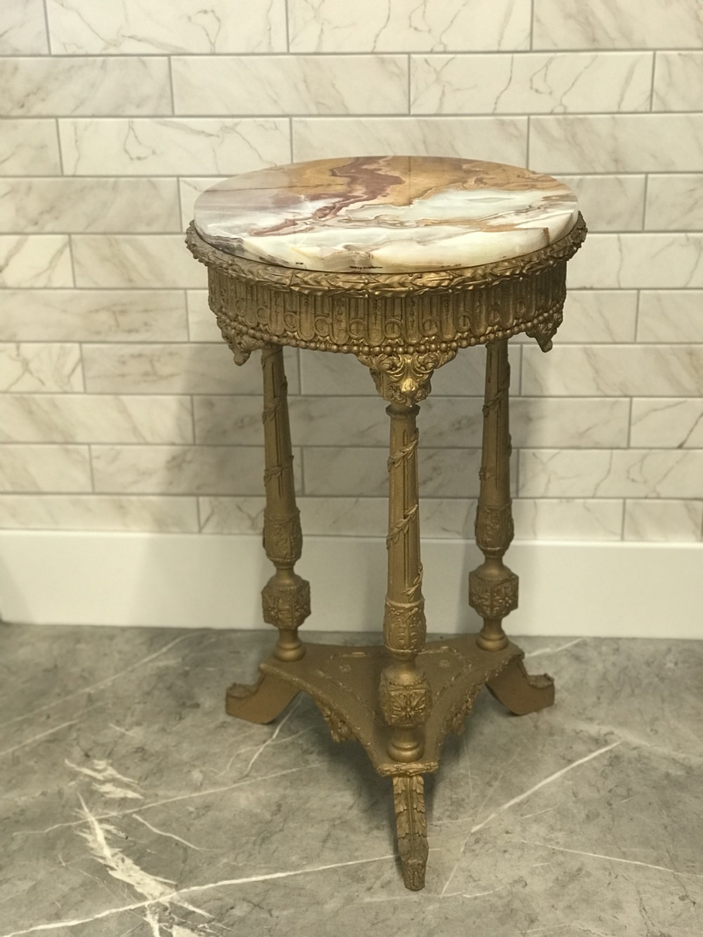 A 19th-century French round table featuring a variegated onyx top, a gilt frieze with decorative mouldings, and three carved column supports above a triangular base. View VII