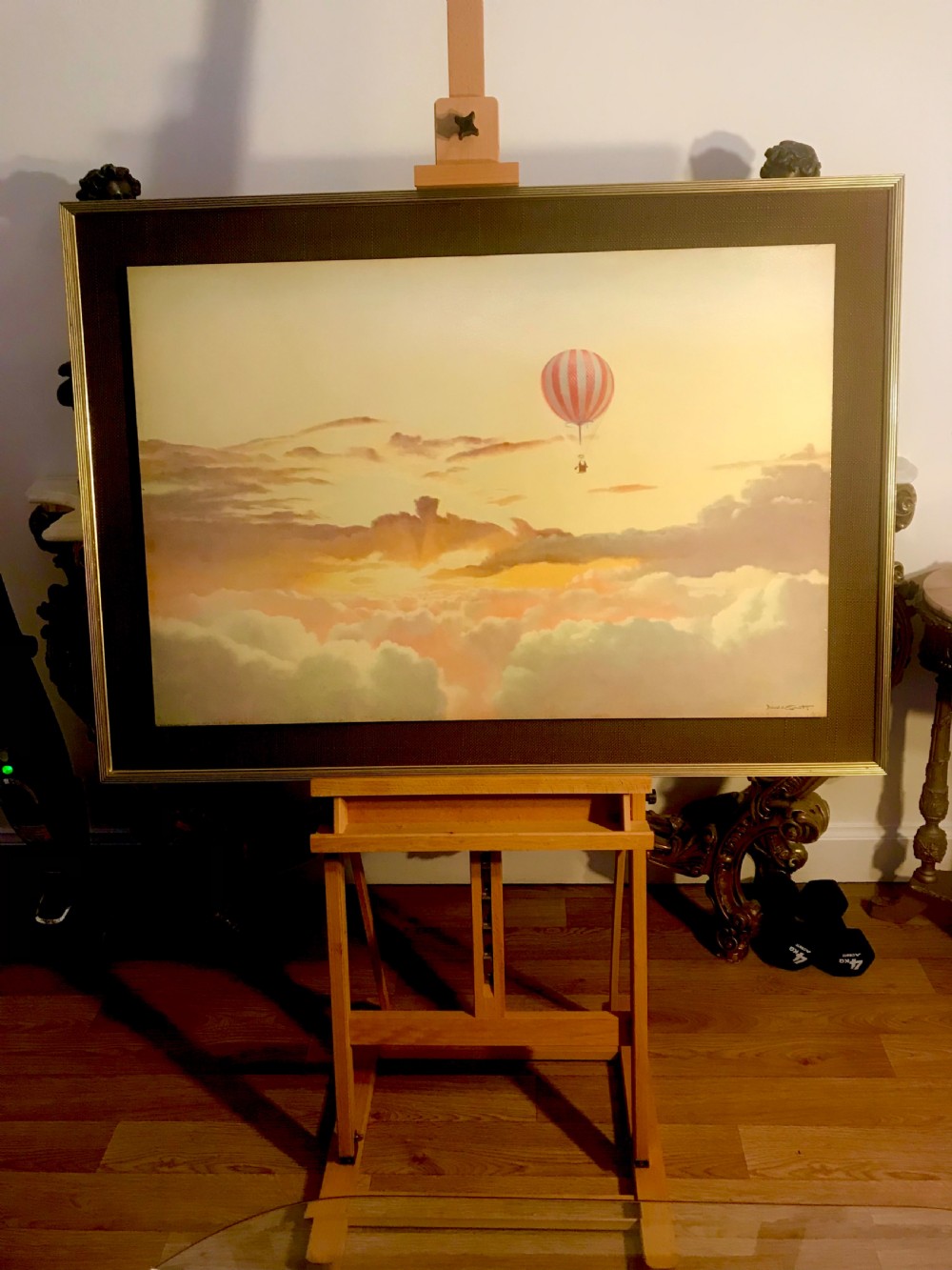 A large horizontal lithograph depicting a red and white striped hot air balloon floating above golden sunset clouds. View II