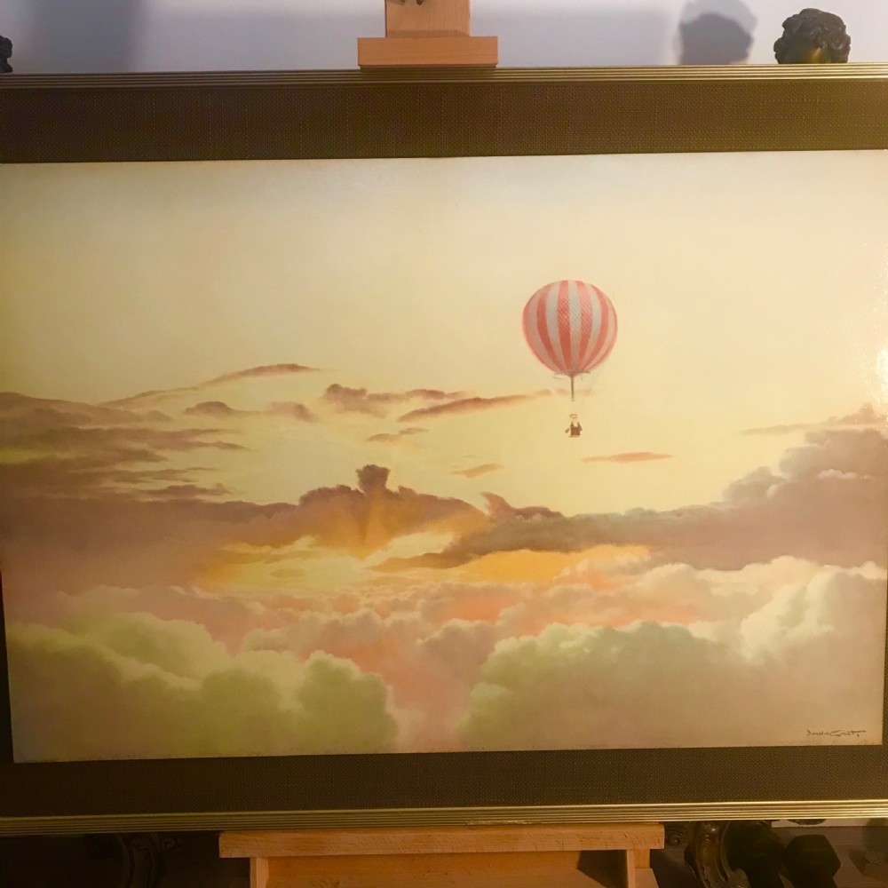 A large horizontal lithograph depicting a red and white striped hot air balloon floating above golden sunset clouds. View III