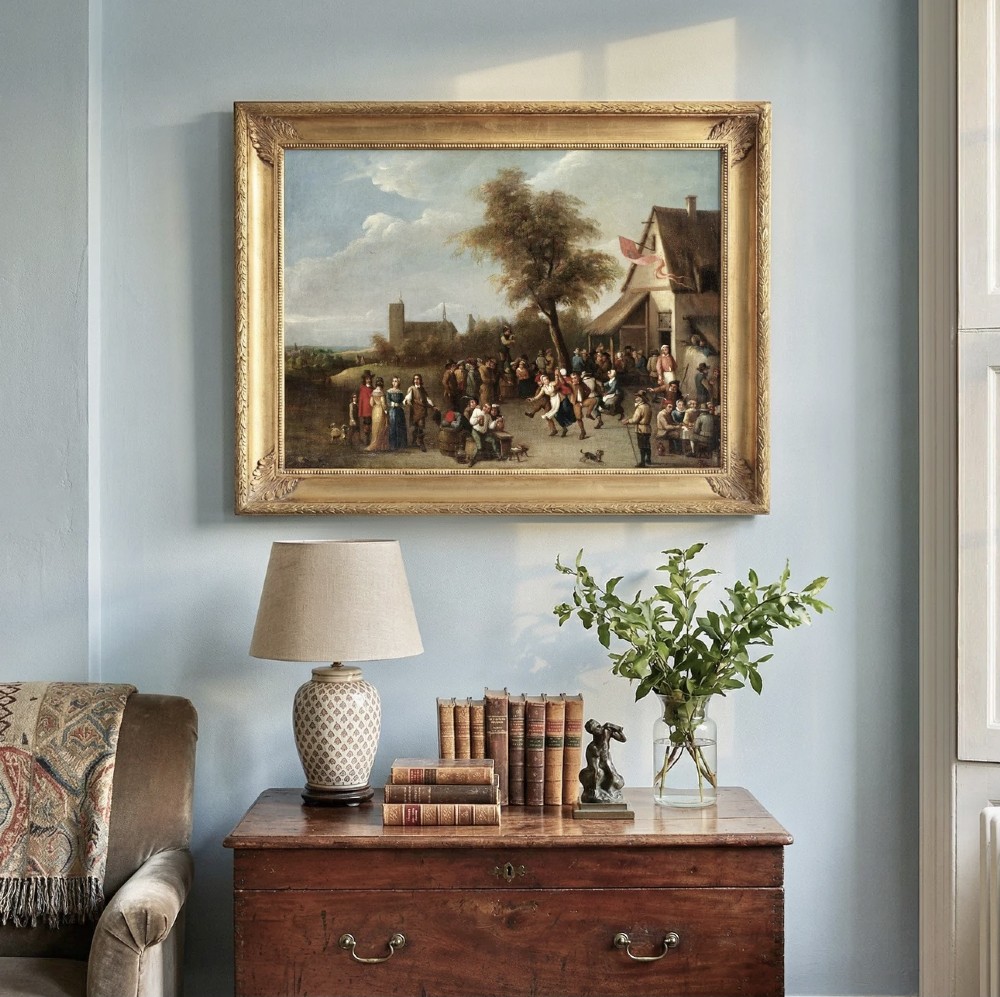 An oil painting in a gilded frame depicting peasants dancing and gathering outside a rustic village tavern in an expansive landscape. View VIII