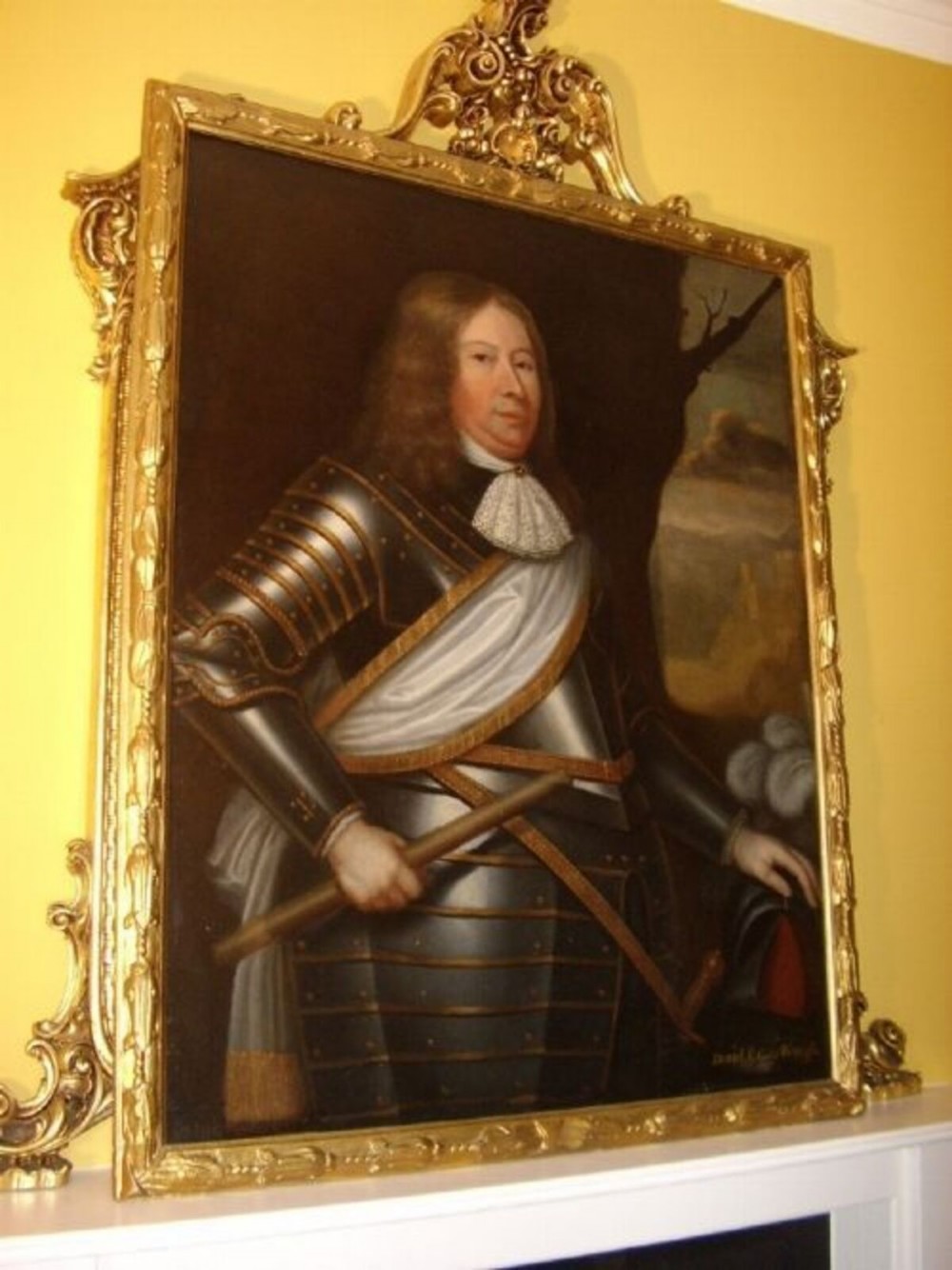 A seventeenth-century oil painting portraying a gentleman in plate armour with a lace cravat, set within an ornate gilded frame. View IX