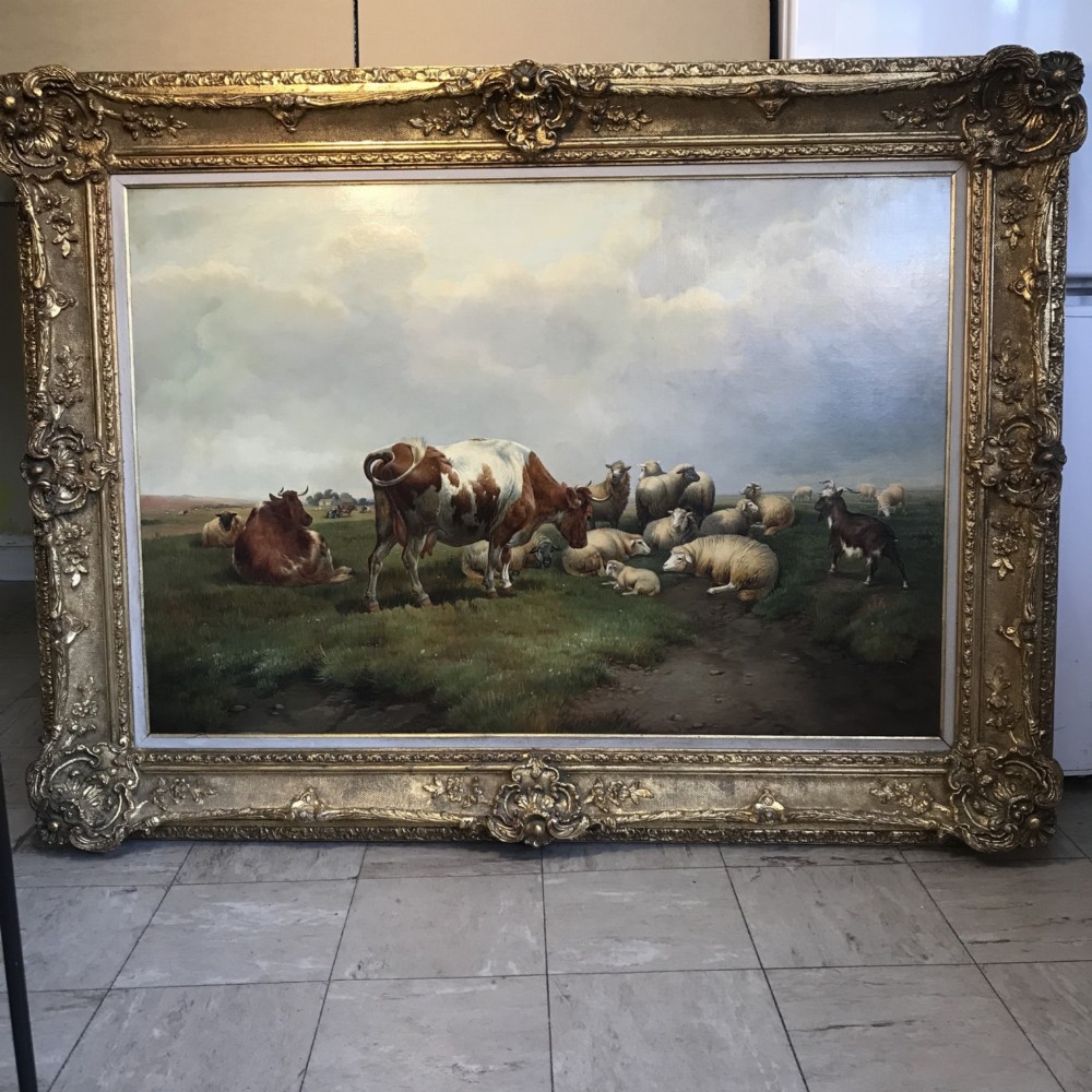 A large 19th-century oil painting depicting cattle and sheep resting in a grassy pasture, set within an ornate carved giltwood frame. View XII