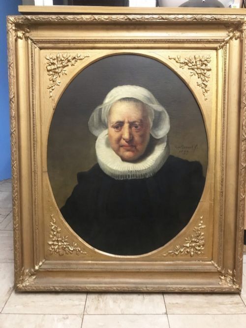 An 18th-century oil portrait of an elderly woman wearing a white bonnet and ruff collar, set inside an oval spandrel within a rectangular gilded frame.