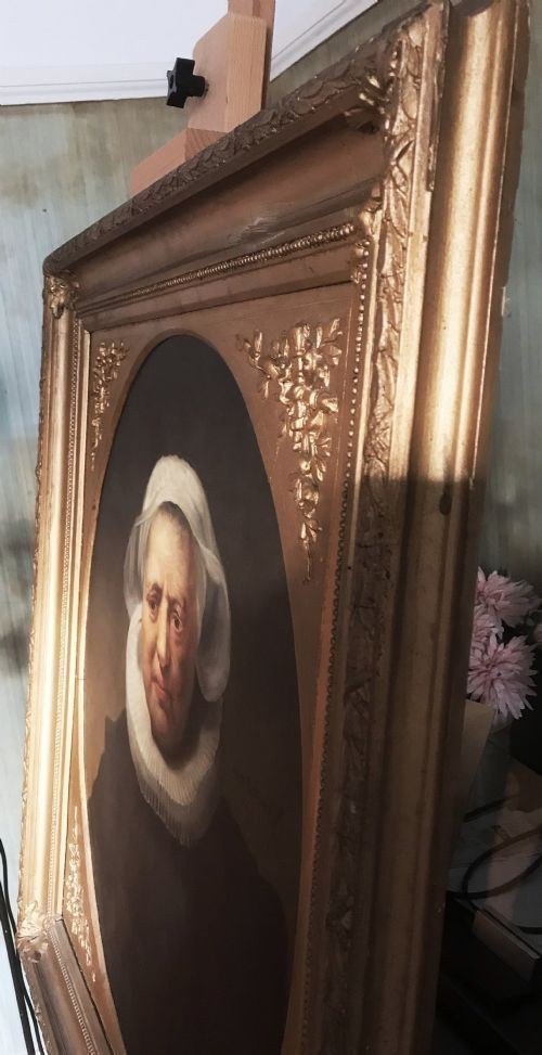 An 18th-century oil portrait of an elderly woman wearing a white bonnet and ruff collar, set inside an oval spandrel within a rectangular gilded frame. View IV