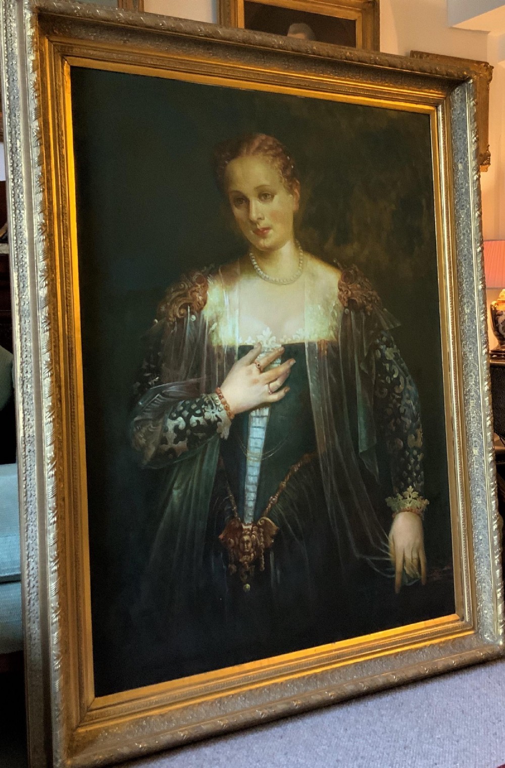 A framed oil portrait depicting a Venetian noblewoman wearing a dark gown, pearl necklace, and transparent veil, presented in a moulded gilded frame. View IV