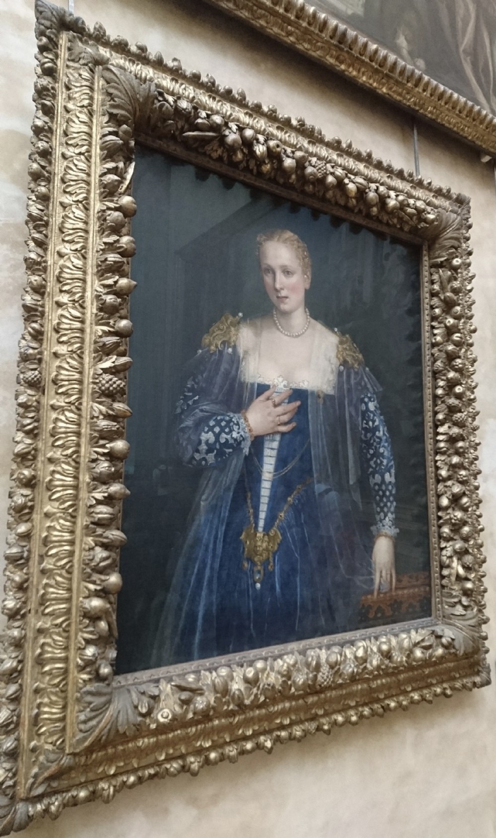 A framed oil portrait depicting a Venetian noblewoman wearing a dark gown, pearl necklace, and transparent veil, presented in a moulded gilded frame. View XIII