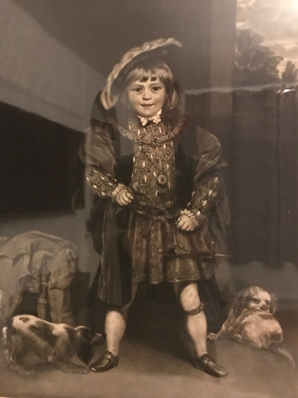 A framed black and white mezzotint print depicting a young boy in historical dress posing as Henry VIII. View VI