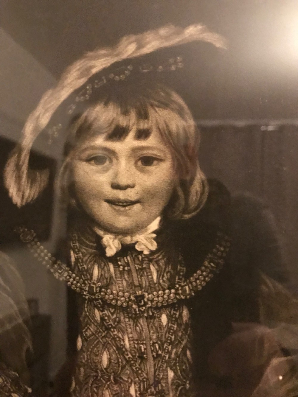 A framed black and white mezzotint print depicting a young boy in historical dress posing as Henry VIII. View IX