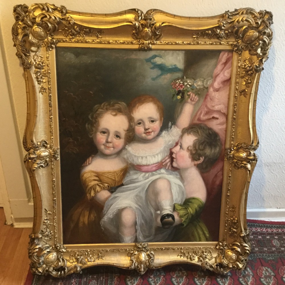A 19th-century oil portrait of three children in classical attire contained within a carved swept giltwood frame. View IV