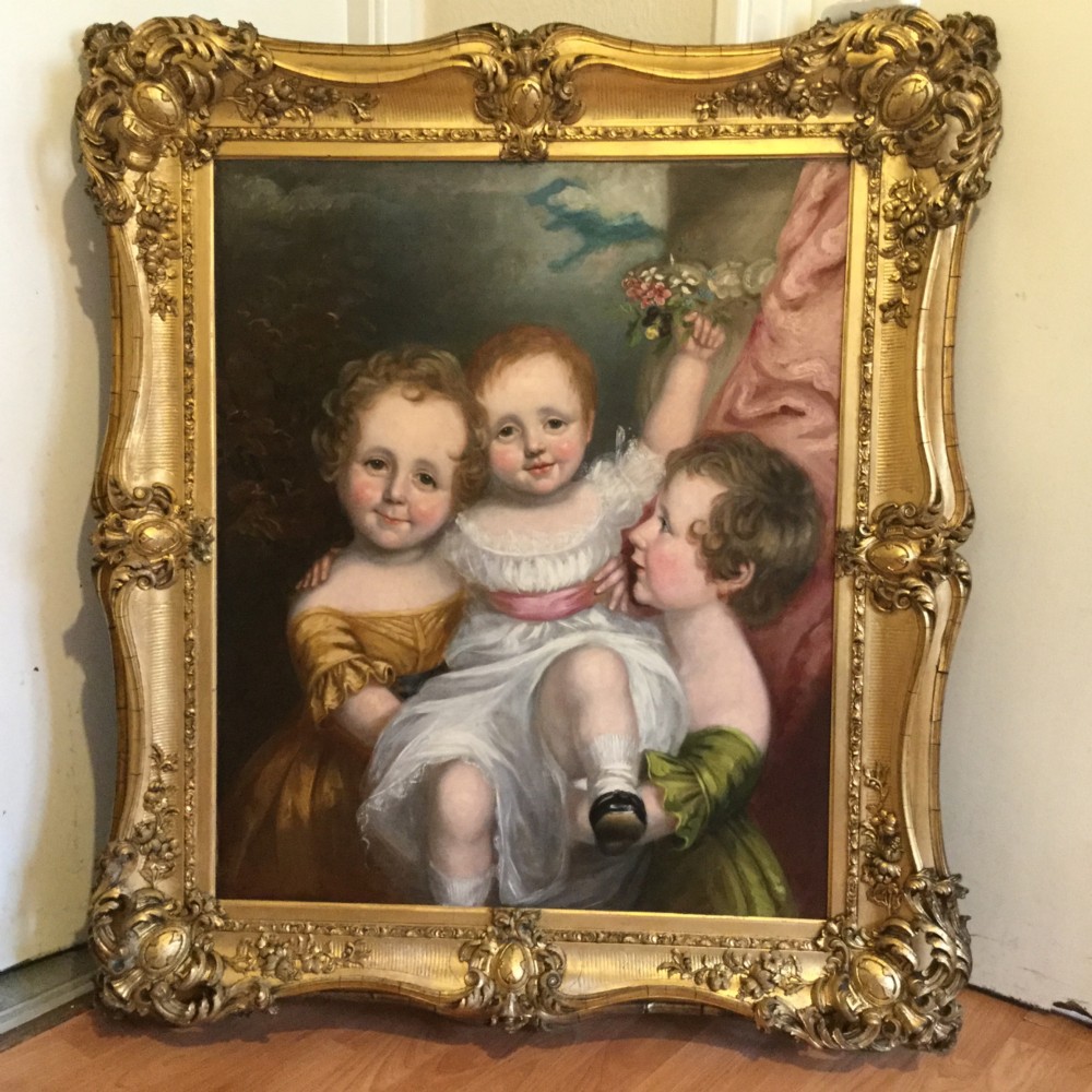 A 19th-century oil portrait of three children in classical attire contained within a carved swept giltwood frame. View XII