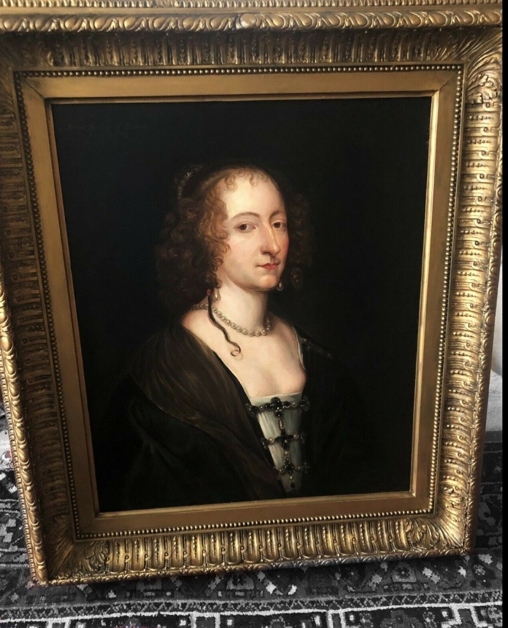 A seventeenth-century oil portrait depicting a noblewoman wearing a pearl necklace and dark drape, set within an ornate gilded frame. View IV