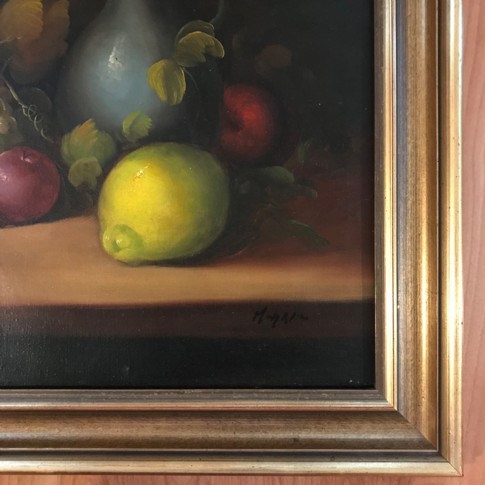An oil painting on canvas depicting a fruit still life composition with pomegranates, grapes, apples, and a pewter jug set within a moulded gold frame. View IX