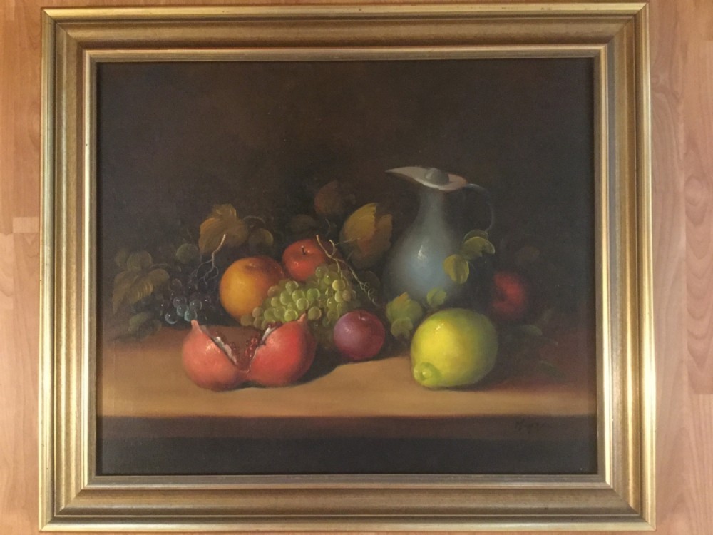 An oil painting on canvas depicting a fruit still life composition with pomegranates, grapes, apples, and a pewter jug set within a moulded gold frame. View XI