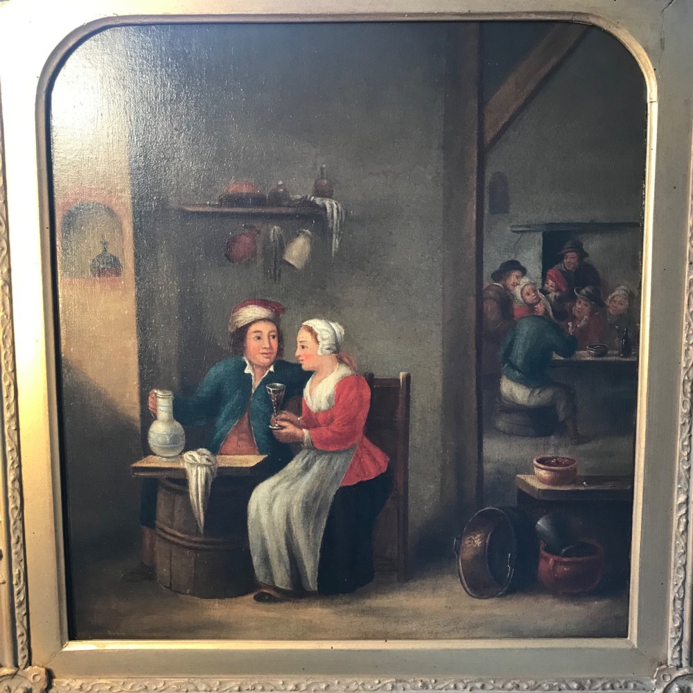 An 18th-century style oil painting depicting figures inside a tavern interior, set within a carved gold giltwood frame. View X