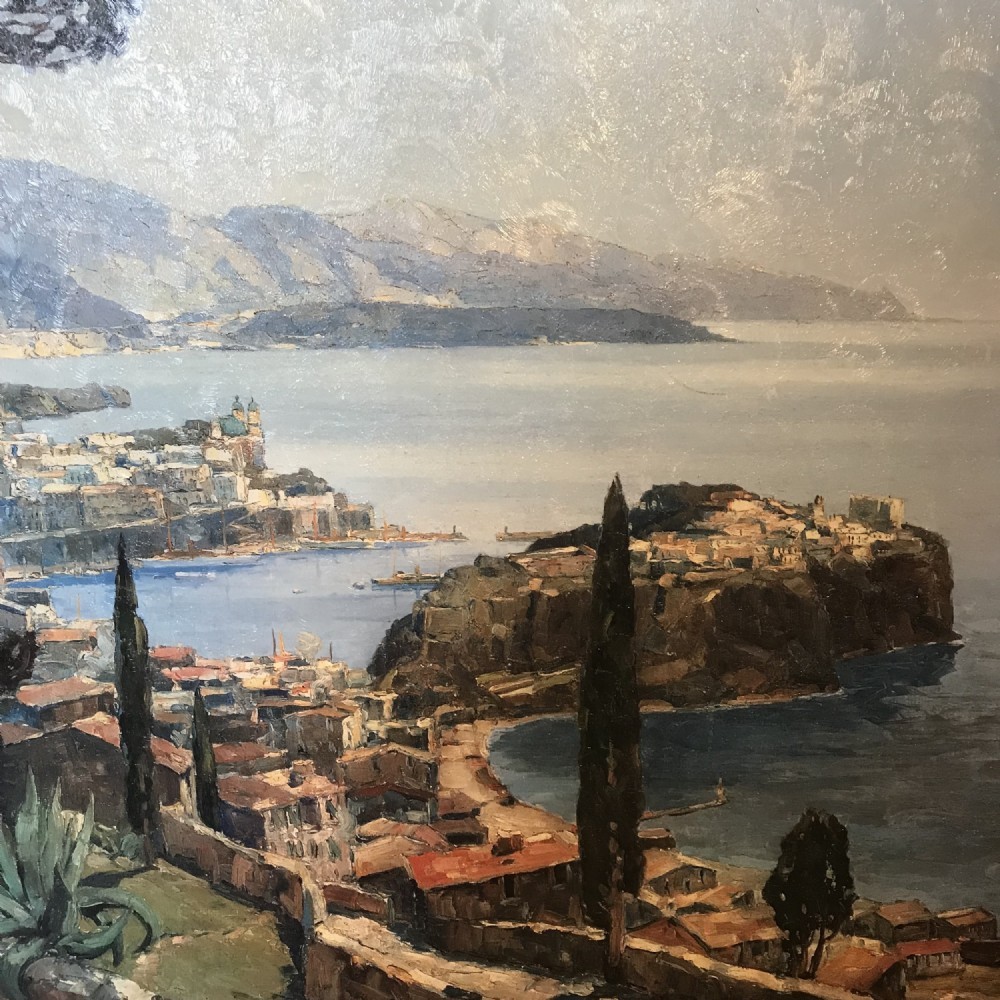 A large framed landscape print depicting a coastal vista of Monaco with cypress trees and stone walls overlooking the sea, set within a gilded frame. View VII