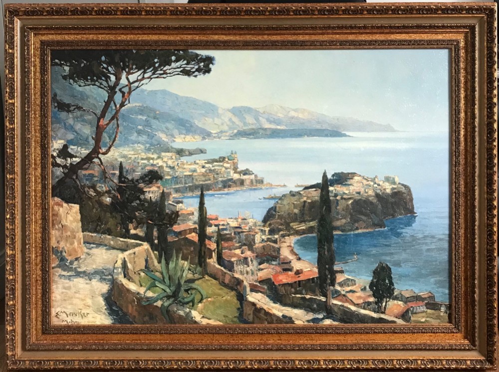 A large framed landscape print depicting a coastal vista of Monaco with cypress trees and stone walls overlooking the sea, set within a gilded frame. View XIII