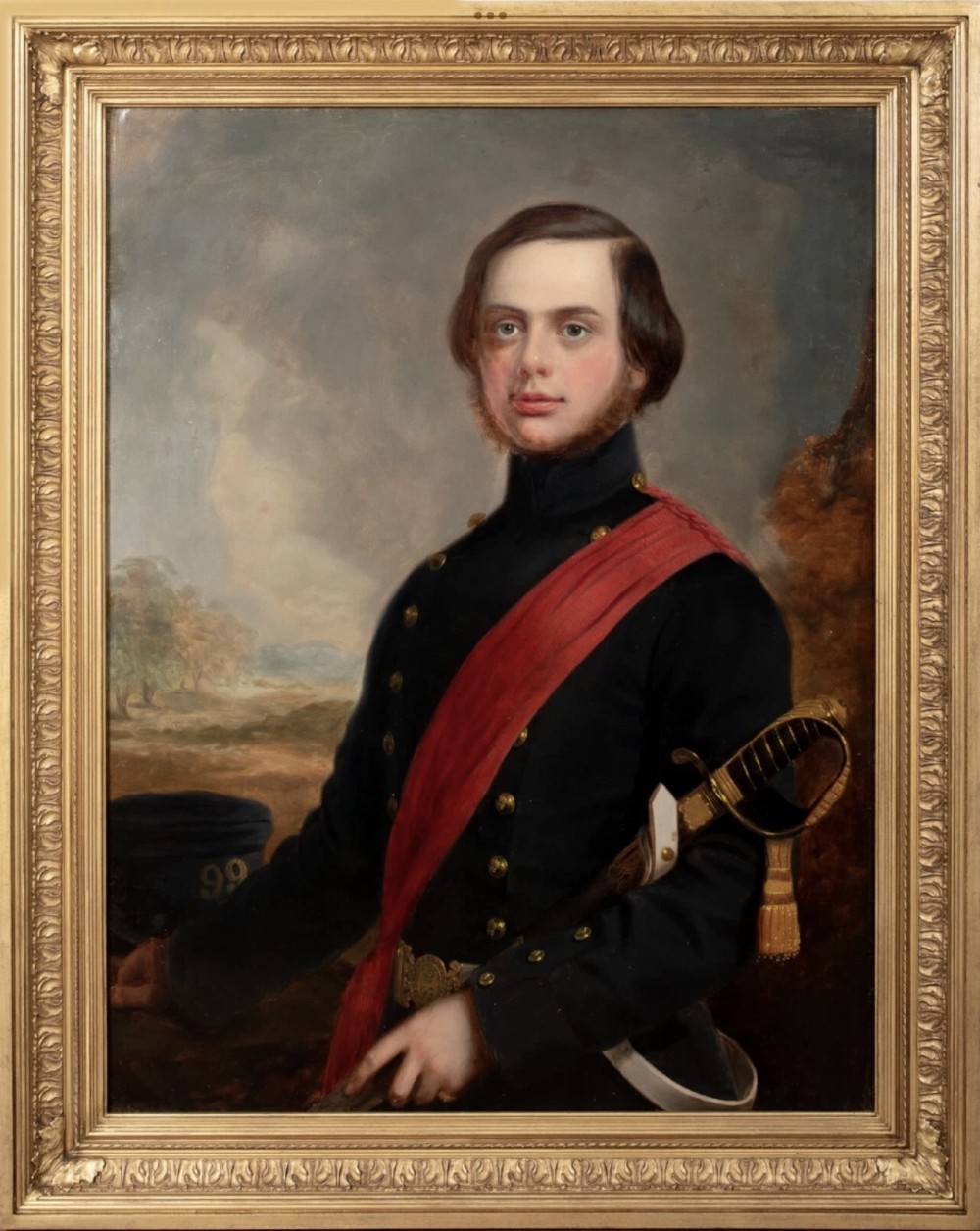 A nineteenth-century oil painting on canvas depicting a young military officer in a dark uniform with a red sash and sword, set within an ornate gilded frame.