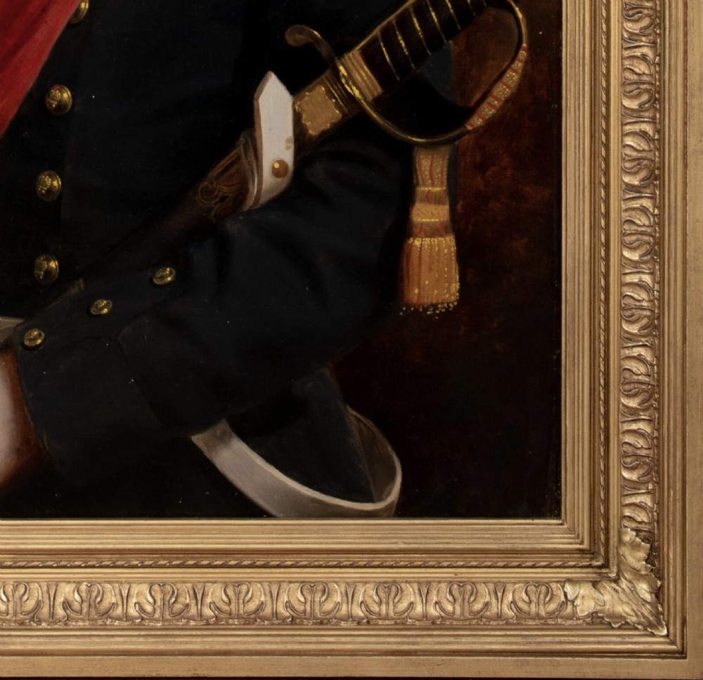 A nineteenth-century oil painting on canvas depicting a young military officer in a dark uniform with a red sash and sword, set within an ornate gilded frame. View IX