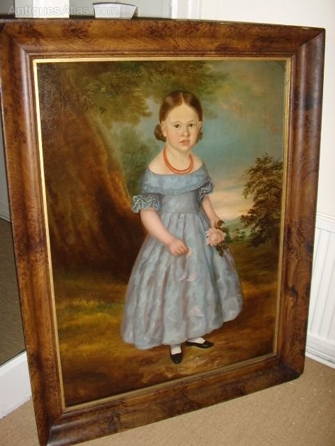 An antique oil portrait on canvas depicting a young girl in a blue dress holding a rose, displayed within a wide flame wood frame. View XIII
