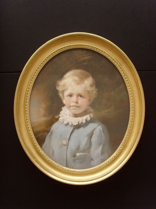 An oval 19th-century pastel portrait of a young boy with blond hair wearing a blue jacket, presented in a moulded gilt frame. View X