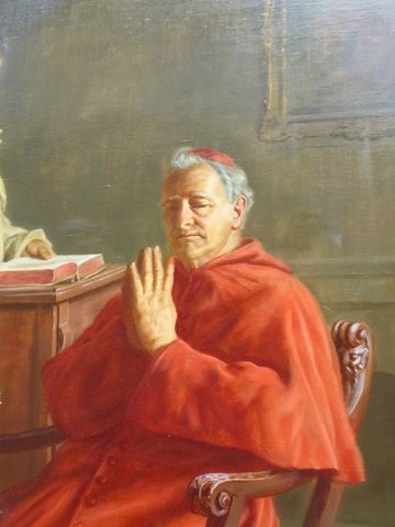 A 19th-century framed oil painting depicting a Vatican cardinal in red robes sitting in prayer beside a monk at a book-laden table. View V