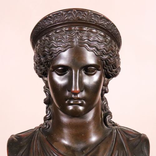 fig 1. A dark brown Neoclassical electrotype bronze bust depicting the classical goddess Juno Ludovisi, featuring a diadem, wavy hair, draped garments, and a turned circular socle.