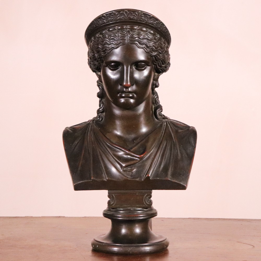 A dark brown Neoclassical electrotype bronze bust depicting the classical goddess Juno Ludovisi, featuring a diadem, wavy hair, draped garments, and a turned circular socle.