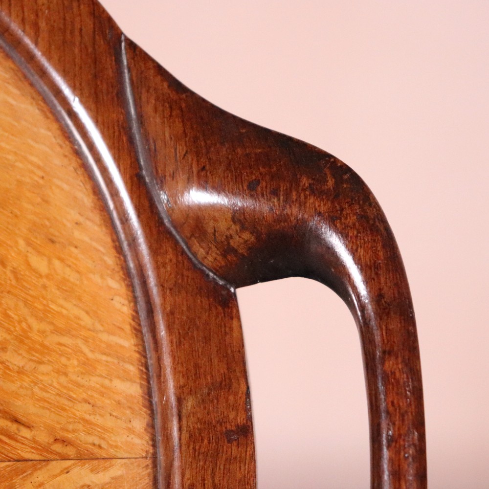 An oval antique tray featuring a central sunburst parquetry design of contrasting specimen woods with carved side handles. View IV