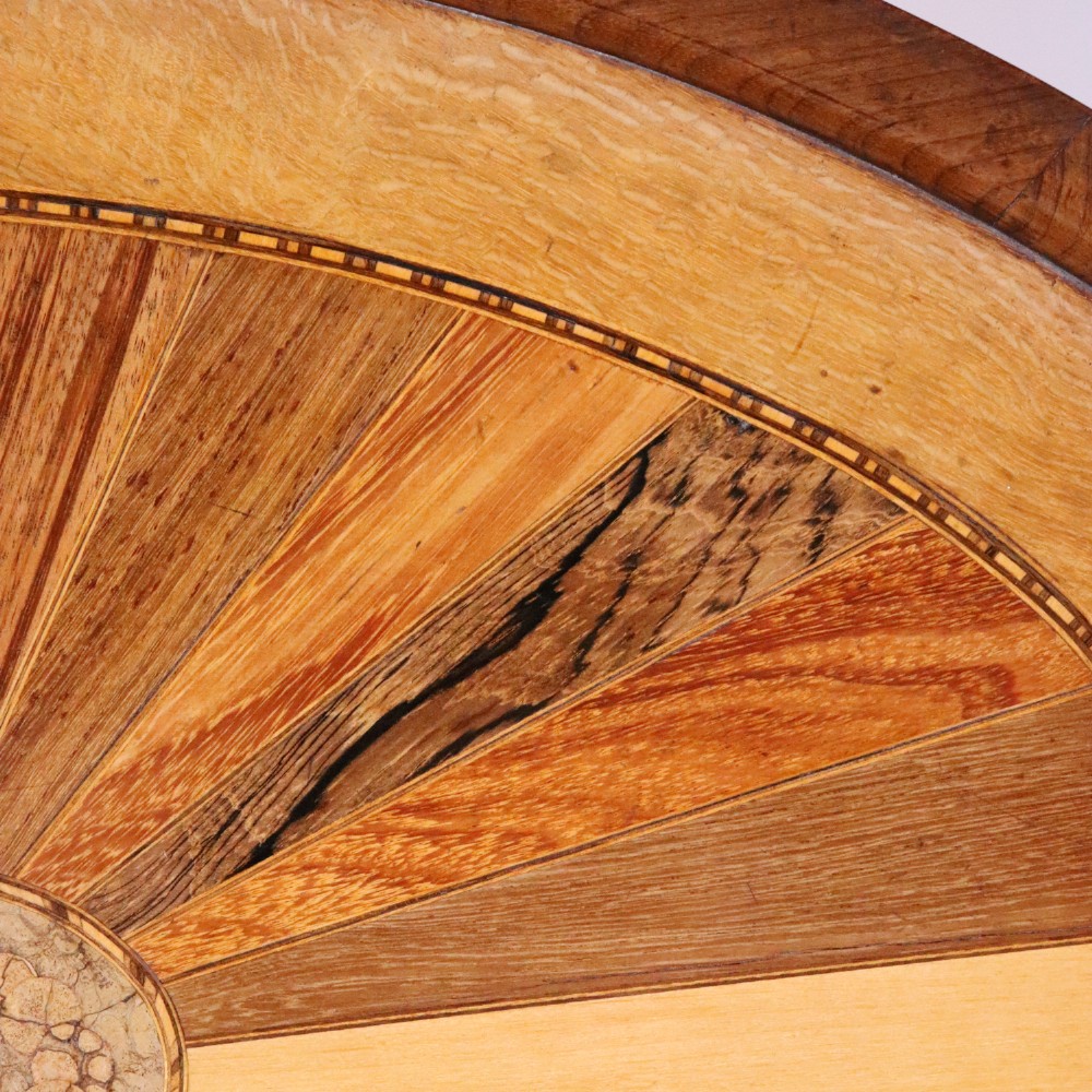 An oval antique tray featuring a central sunburst parquetry design of contrasting specimen woods with carved side handles. View VI