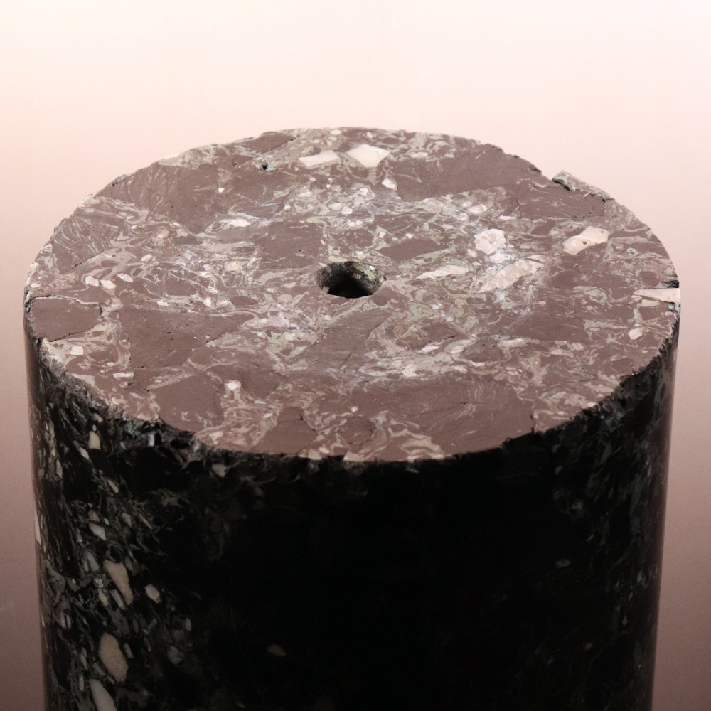 An early nineteenth-century cylindrical scagliola column pedestal with a dark green speckled faux-marble finish resting on a moulded off-white circular base. View II