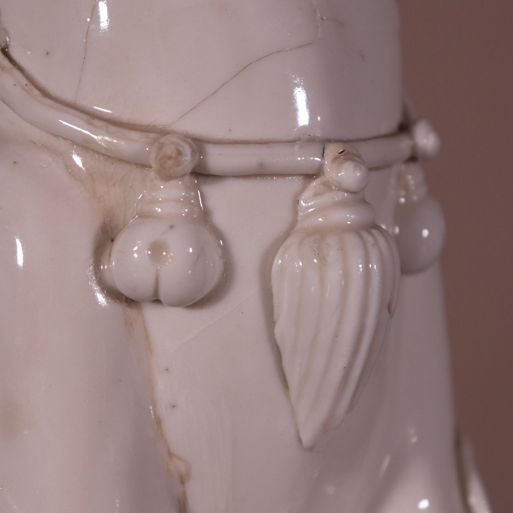 A pair of 18th-century cream-glazed Blanc de Chine porcelain guardian lion statues seated upright on rectangular bases. View VIII