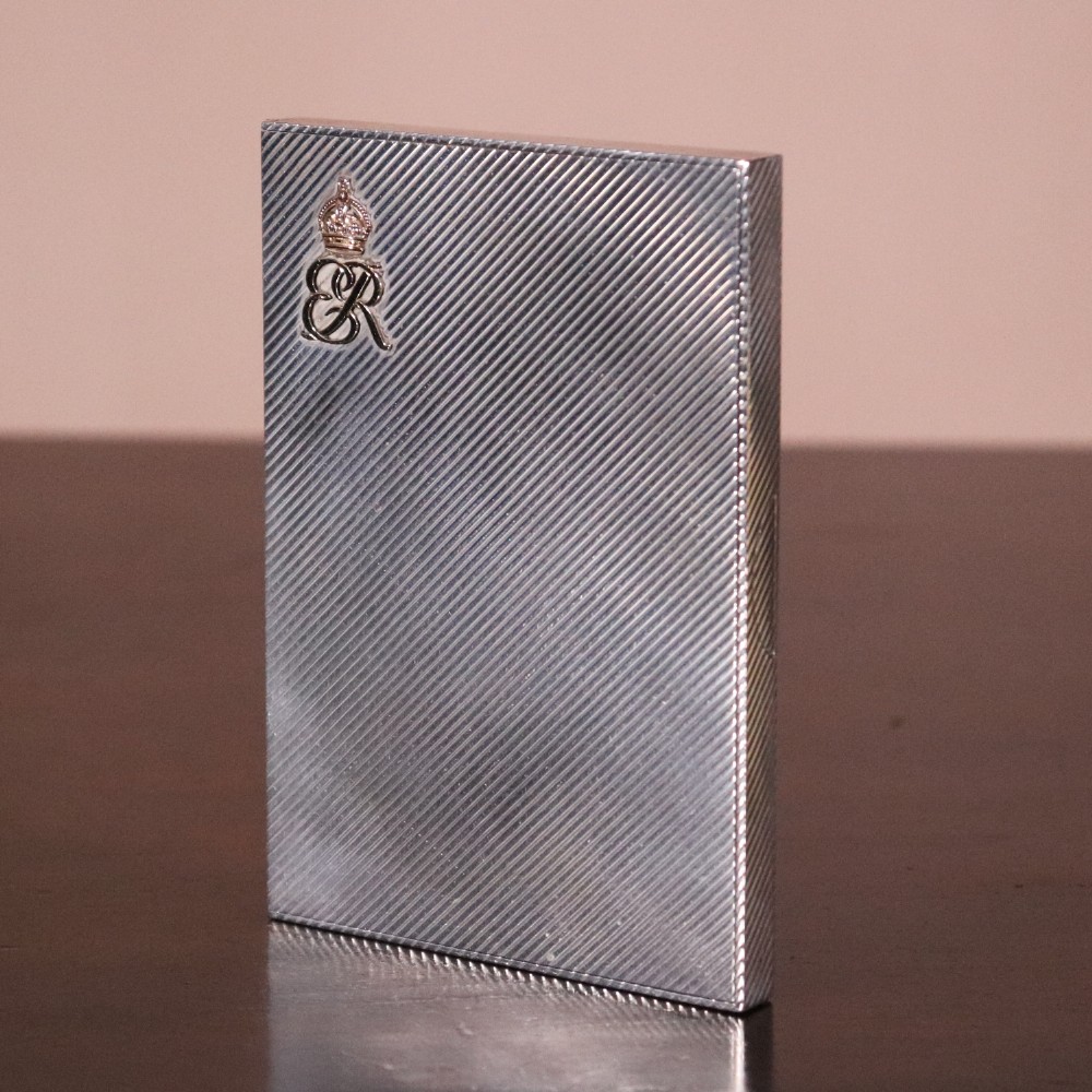 An engine-turned silver and gold mounted Cartier notelet case presented inside an open red leather fitted box alongside written correspondence. View II