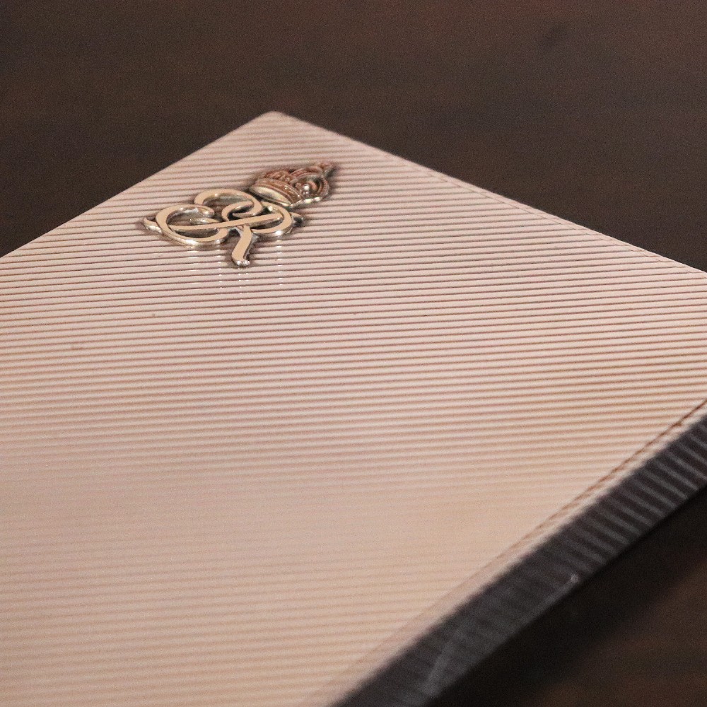 An engine-turned silver and gold mounted Cartier notelet case presented inside an open red leather fitted box alongside written correspondence. View IV