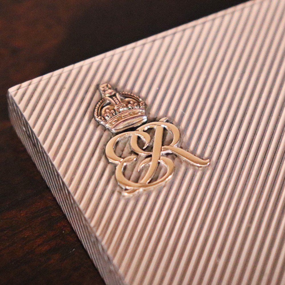 An engine-turned silver and gold mounted Cartier notelet case presented inside an open red leather fitted box alongside written correspondence. View VI