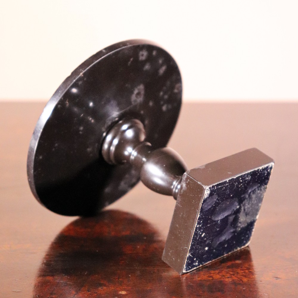 A nineteenth-century Ashford black marble miniature table featuring a round top inlaid with colourful geometric marble specimens, supported by a turned baluster column on a square plinth base. View III