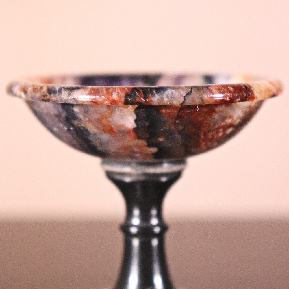 A small nineteenth-century tazza featuring a shallow turned Blue John bowl with purple and brown banding, set upon a black turned marble stem and square base. View VII