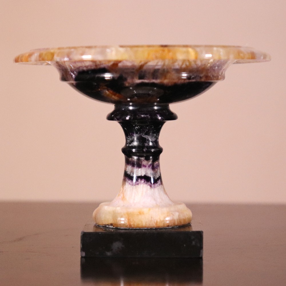 A small 19th-century Blue John fluorite tazza with purple and yellow banding, mounted on a turned stem and a square black marble base. View II
