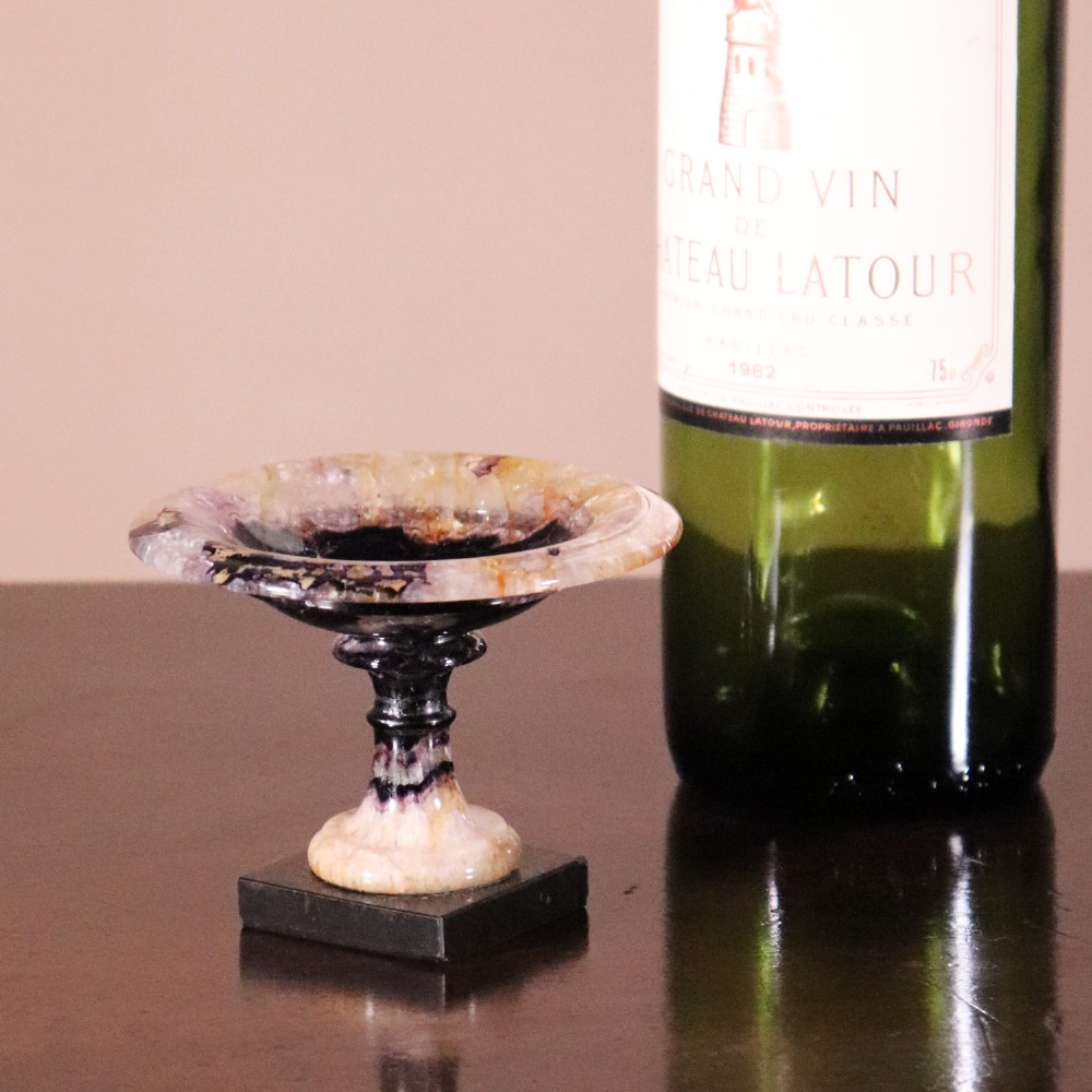 A small 19th-century Blue John fluorite tazza with purple and yellow banding, mounted on a turned stem and a square black marble base. View X