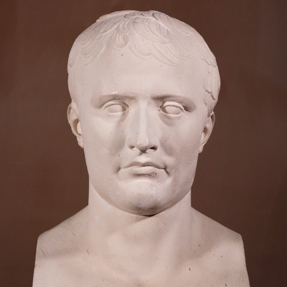 An off-white plaster portrait bust depicting Napoleon Bonaparte with short classical hair and a square pedestal base. View II