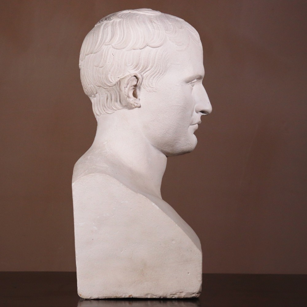 An off-white plaster portrait bust depicting Napoleon Bonaparte with short classical hair and a square pedestal base. View III