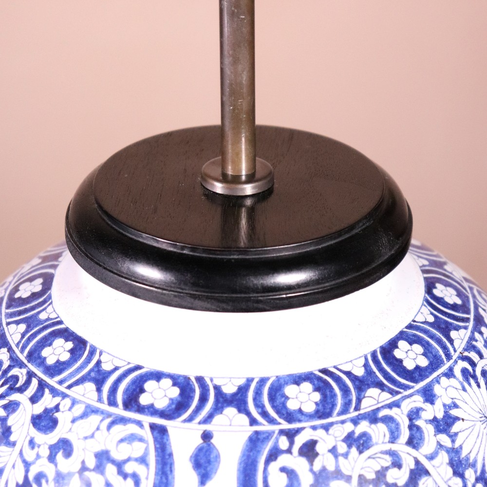 A pair of Chinese style blue and white porcelain ginger jar table lamps featuring floral panels mounted on dark wooden bases. View III