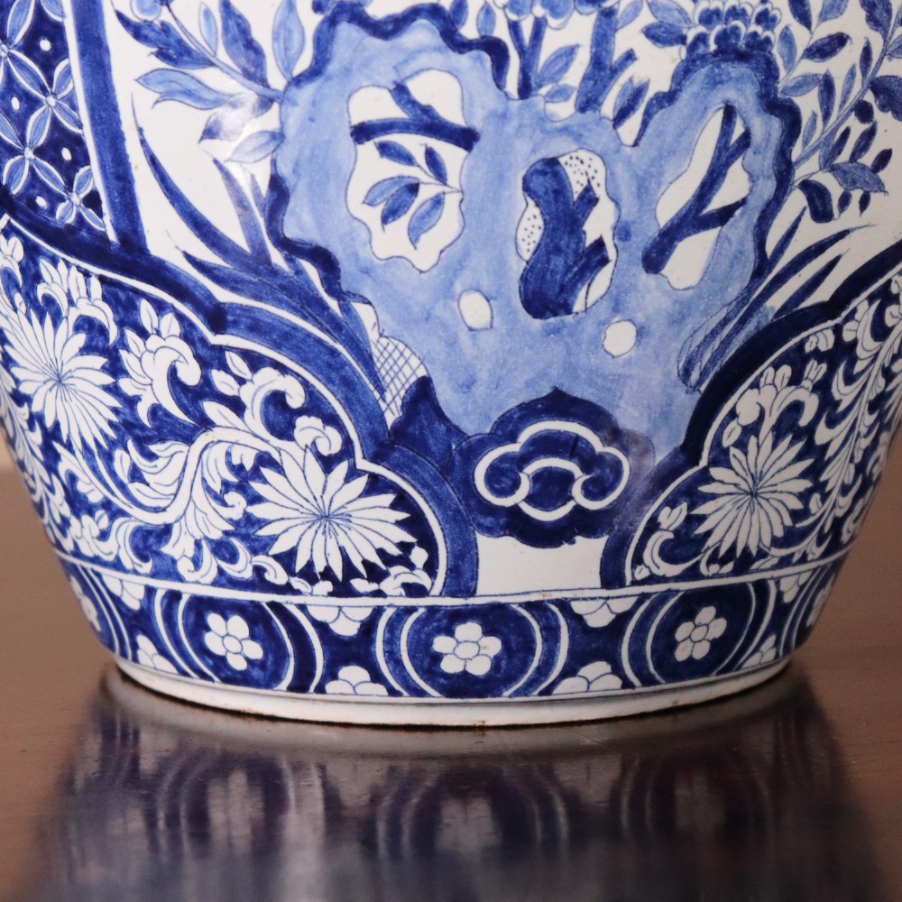 A pair of Chinese style blue and white porcelain ginger jar table lamps featuring floral panels mounted on dark wooden bases. View V