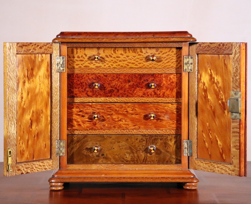 A 19th-century wooden table cabinet with two doors featuring inlaid star motifs set within pointed arches, resting on turned bun feet. View V